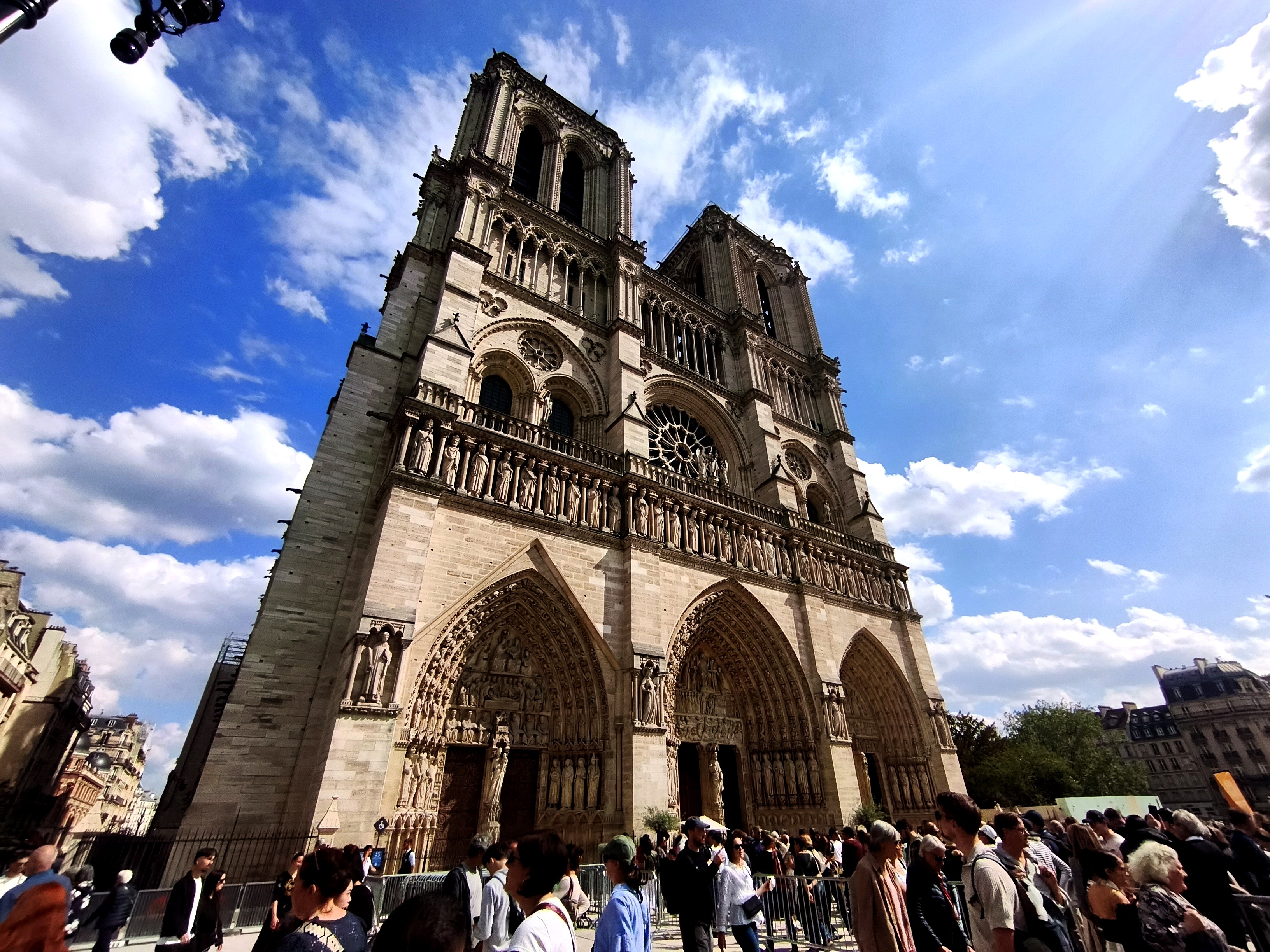 Façade occidentale de la cathédrale Notre-Dame de Paris et foule de visiteurs sur le parvis