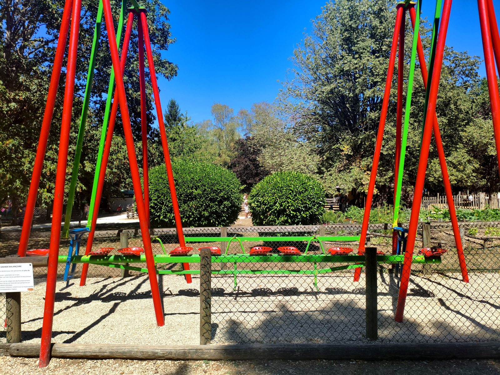 Grande balançoire collective rouge et verte du parc de l'Auxois