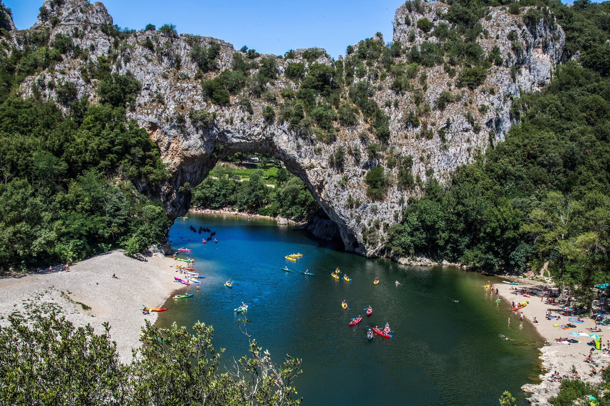 Canoës sur la rivière Ardèche sous l'arche naturelle du Pont d'Arc, près de Vallon-Pont-d'Arc