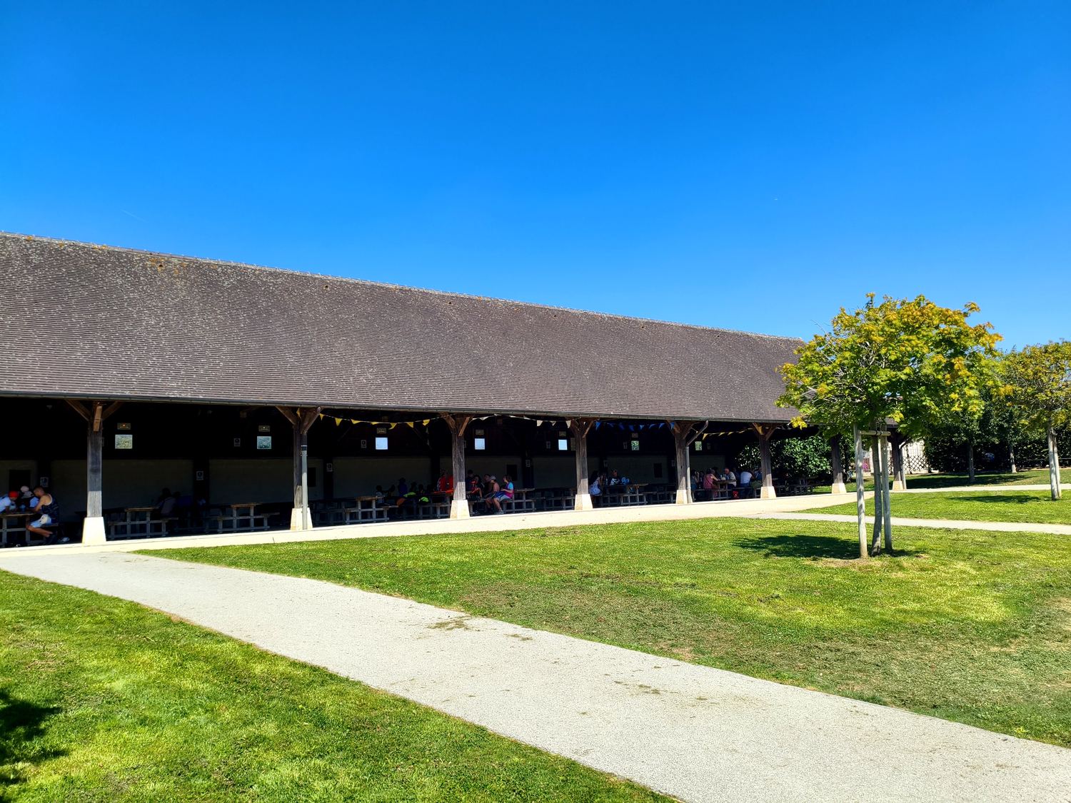 L'aire de pique-nique couverte de l'office de tourisme de Provins, avec ses grandes tables en bois à l'ombre
