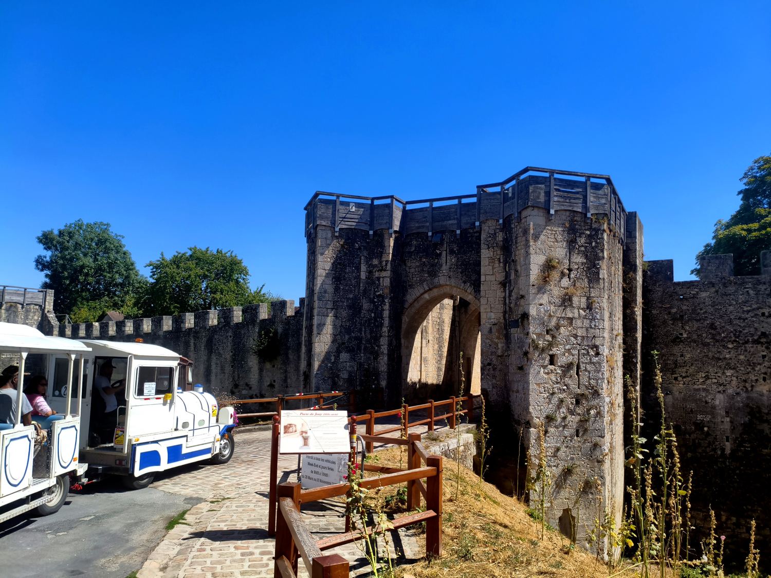 Le petit train de Provins arrêté devant une porte fortifiée des remparts de la ville haute